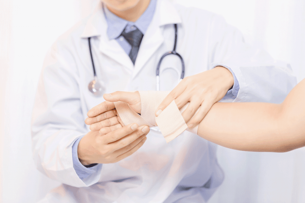 Male Doctor Putting Gauze On Young Man S Hand In Clinic Closeup First Aid